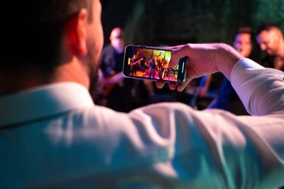 Wedding guest filming the band with a smartphone during live performance