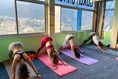 Students practicing yoga poses on a mat during a training session.