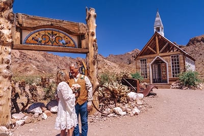 a man and woman standing in front of a church