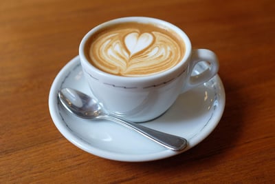 a cup of coffee with a heart shaped design on the side