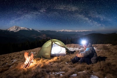 man wearing camping headlamp at night