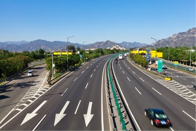 Aerial view of a smart expressway equipped for AI-powered traffic monitoring and dynamic speed management.