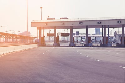 Empty highway toll plaza with sunlight representing an automated toll collection system.