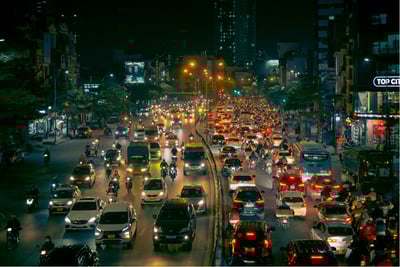 Night view of congested urban traffic with cars and motorcycles under city lights for congestion monitoring.