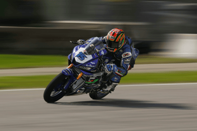 Pilota in azione su moto da corsa, esempio di motociclismo supportato da Noline