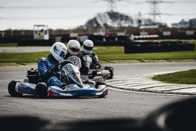 Piloti in gara durante una competizione di karting, esempio di attività motorsport di noline