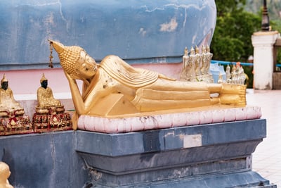A detailed photo of a large, golden reclining Buddha statue at Wat Phra Yai Temple in Koh Samui