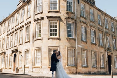 a bride and groom standing in front of a building