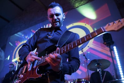 Guitarist giving an intense solo during a high-energy wedding performance