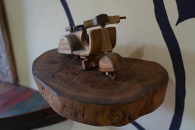 a wooden scooter Vespa sitting on a wooden table at the sunrise lodge and lounge museum bali lovina