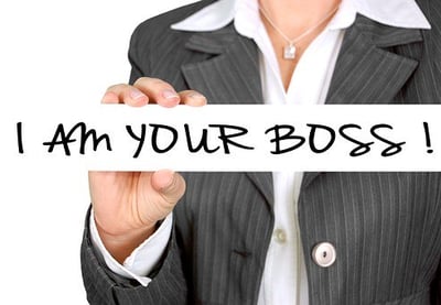 Führungskraft mit Schild „I am your boss“ – Symbol für Rollenwechsel im Führungstraining