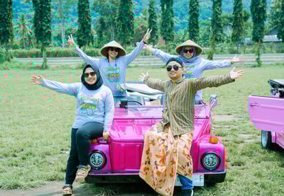 Wisatawan menikmati perjalanan VW Safari melewati pedesaan hijau dengan latar lapangan