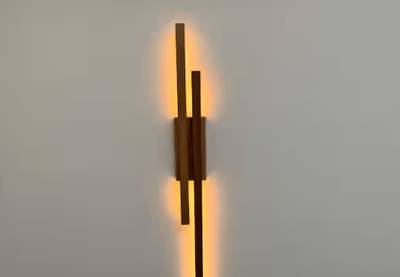 a wall mounted light fixture with a wooden wall