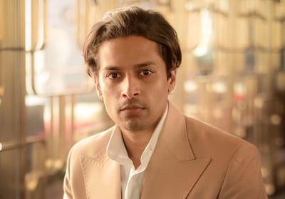 a man in a suit and tie is sitting on a chair