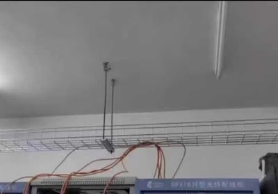 a line of wire mesh cable tray are hanging from the ceiling