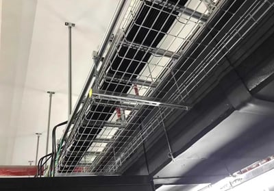 a metal wire mesh cable tray with bundles cables hanging in the ceiling