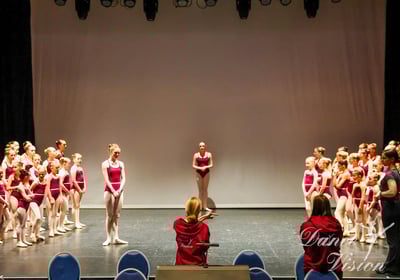 a group of young girls in red and white outfits on stage