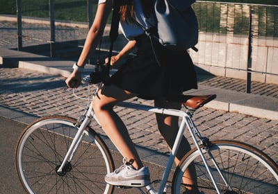 a woman riding a bicycle with a backpack on it