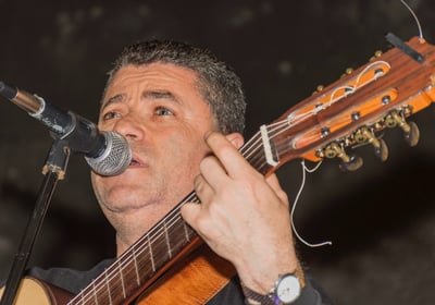 a man with a guitar and a microphone in front of a microphone