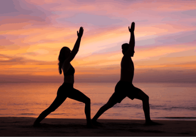 a woman doing yoga exercises on the beach