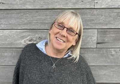 a woman in a gray sweater and glasses