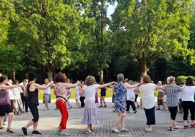 a group of people standing around a circle with their arms outstretched out