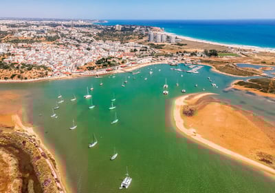 Aerial view of Alvor’s tranquil lagoon with the village and the ocean in the backgr