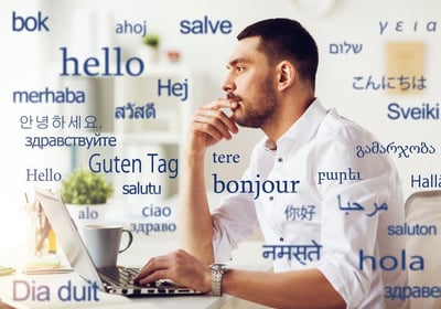 a man sitting at a desk with a laptop computer and a cup of coffee