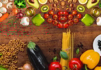 a variety of vegetables and fruits on a wooden table