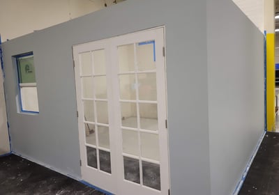 a room with a large white door and a blue wall