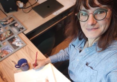 portrait de Marie Hardy fondatrice de Fresh Fresque devant un croquis à main levée à son bureau