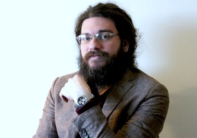 a man with a beard and glasses on a chair