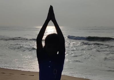 a person doing yoga on a beach
