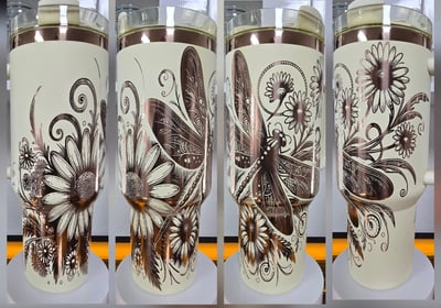 Cream-colored custom tumblers with detailed laser-engraved floral and dragonfly designs – engraved d