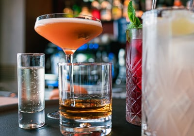 Photo d'une sélection de cocktails variés sur un bar dans une ambiance de bar chic et colorée