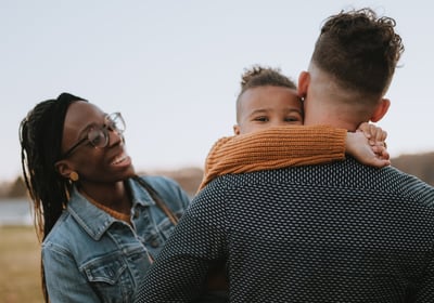 Family in field smiling with child