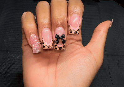 a person's hand with a pink and black nail polish