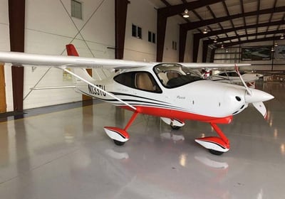 a small plane in a hangar with a red and white stripe