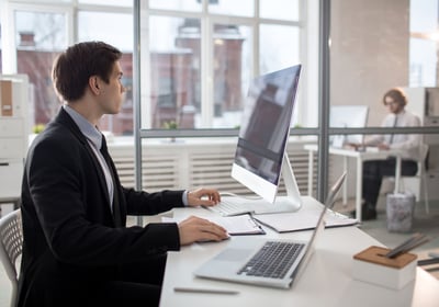 a man sitting at a desk with a laptop and a laptop