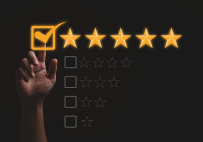 Mano marcando cinco estrellas sobre fondo oscuro, representando una reputación digital positiva basa