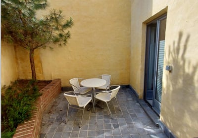 Cour intérieure avec mobilier et végétation accessible depuis un bureau