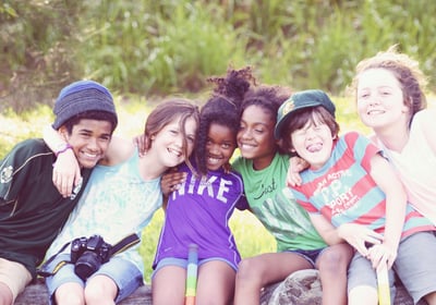 a group of children sitting on a bench in a park