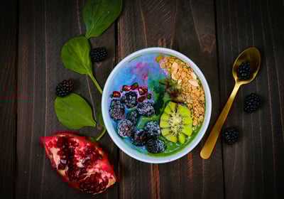 a bowl of fruit and yogurt on a wooden table
