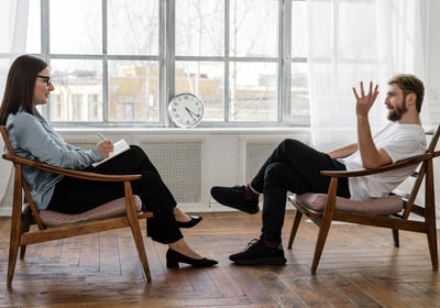 a man and woman sitting in chairs in a room