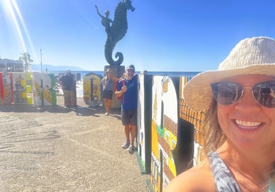 a woman in a hat and sunglasses is taking a selfie