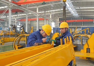 Our team expertly assembles large vehicle mounted cranes in our modern factory, showcasing strong manufacturing capabilities.