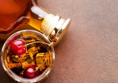 a bottle of honey syrup with cherries and cherries