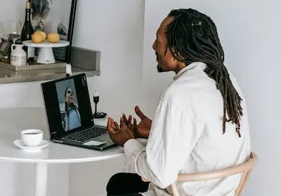 Homem sentado olhando para o computador conversando por video chamada