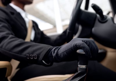 Driver in total black with black golves is driving