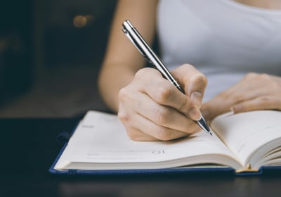 a person writing in a diary